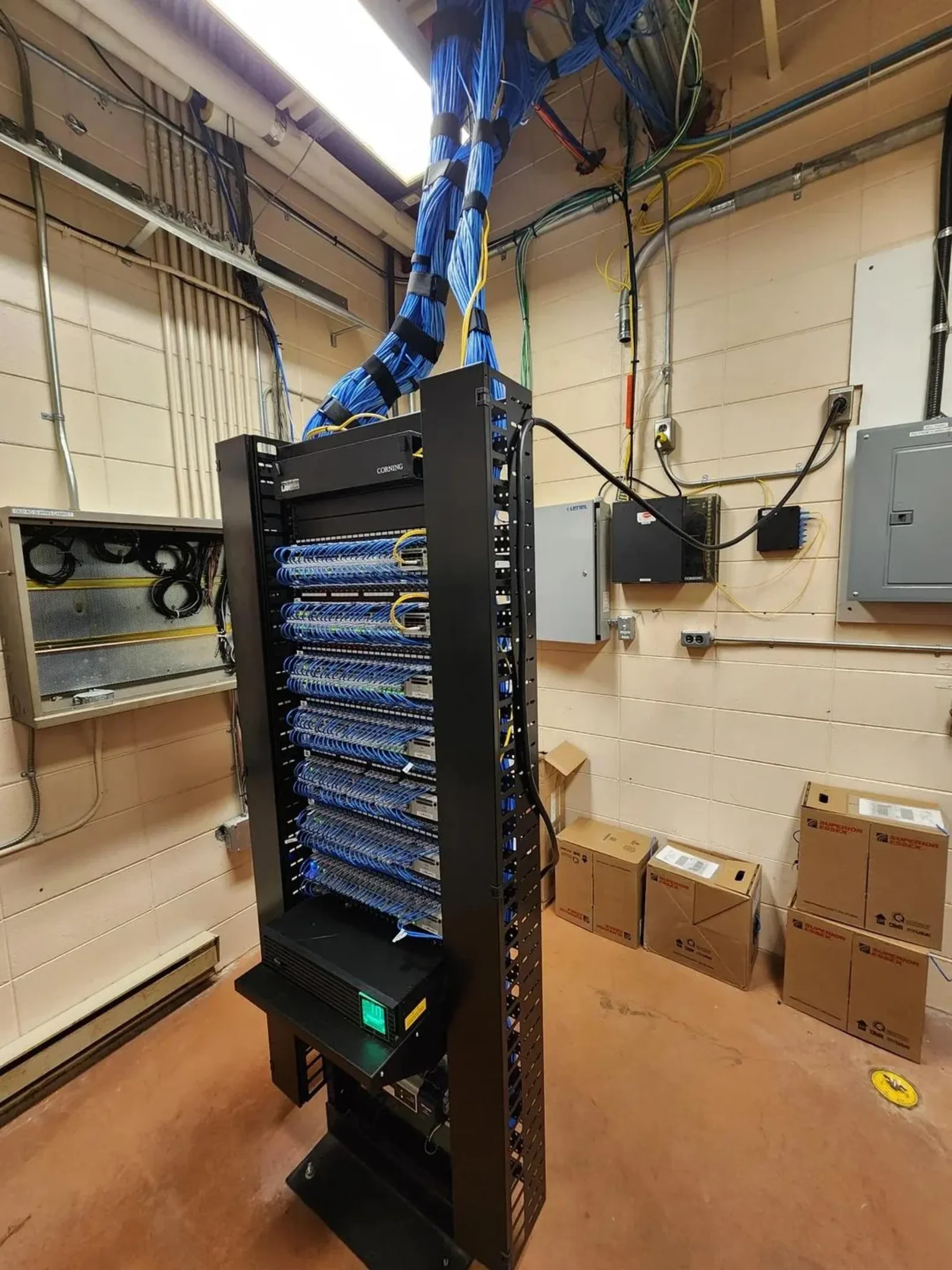 Middle room after cleanup — neatly dressed cables and labeled patch panels (front view)